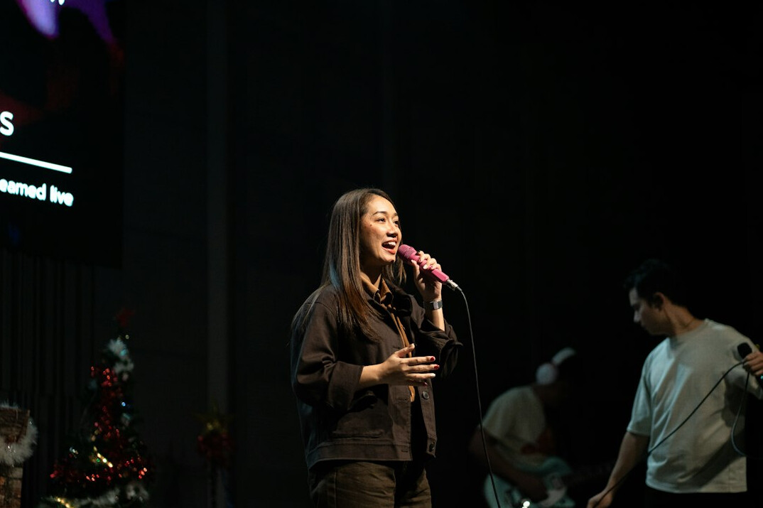 Woman speaking confidently on stage with microphone